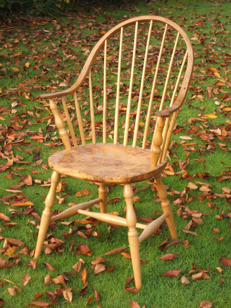 Handmade continuous arm Windsor chair made from local timber, shown outdoors.
