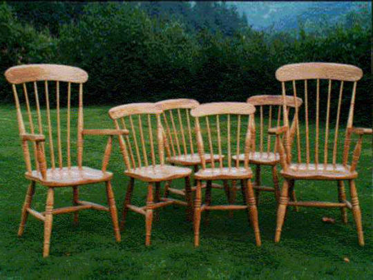 Handmade set of comb back Windsor chairs made from local timber, shown outdoors.