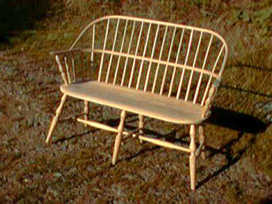 Handmade sack back style two seater settee made from local timber, shown outdoors.