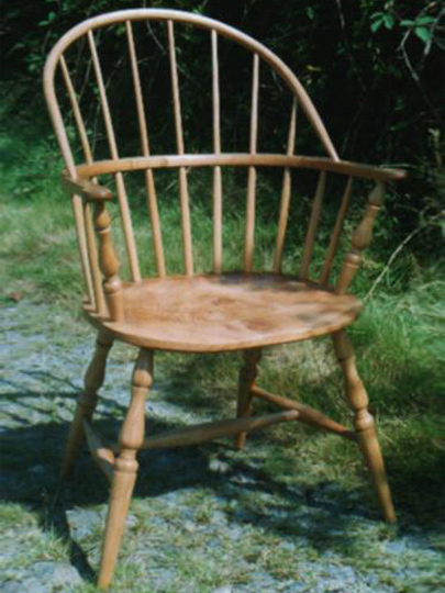 Handmade sack back Windsor chair made from local timber, shown outdoors.