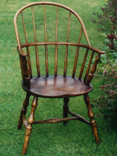 Handmade sack back Windsor chair made from local timber, shown outdoors.