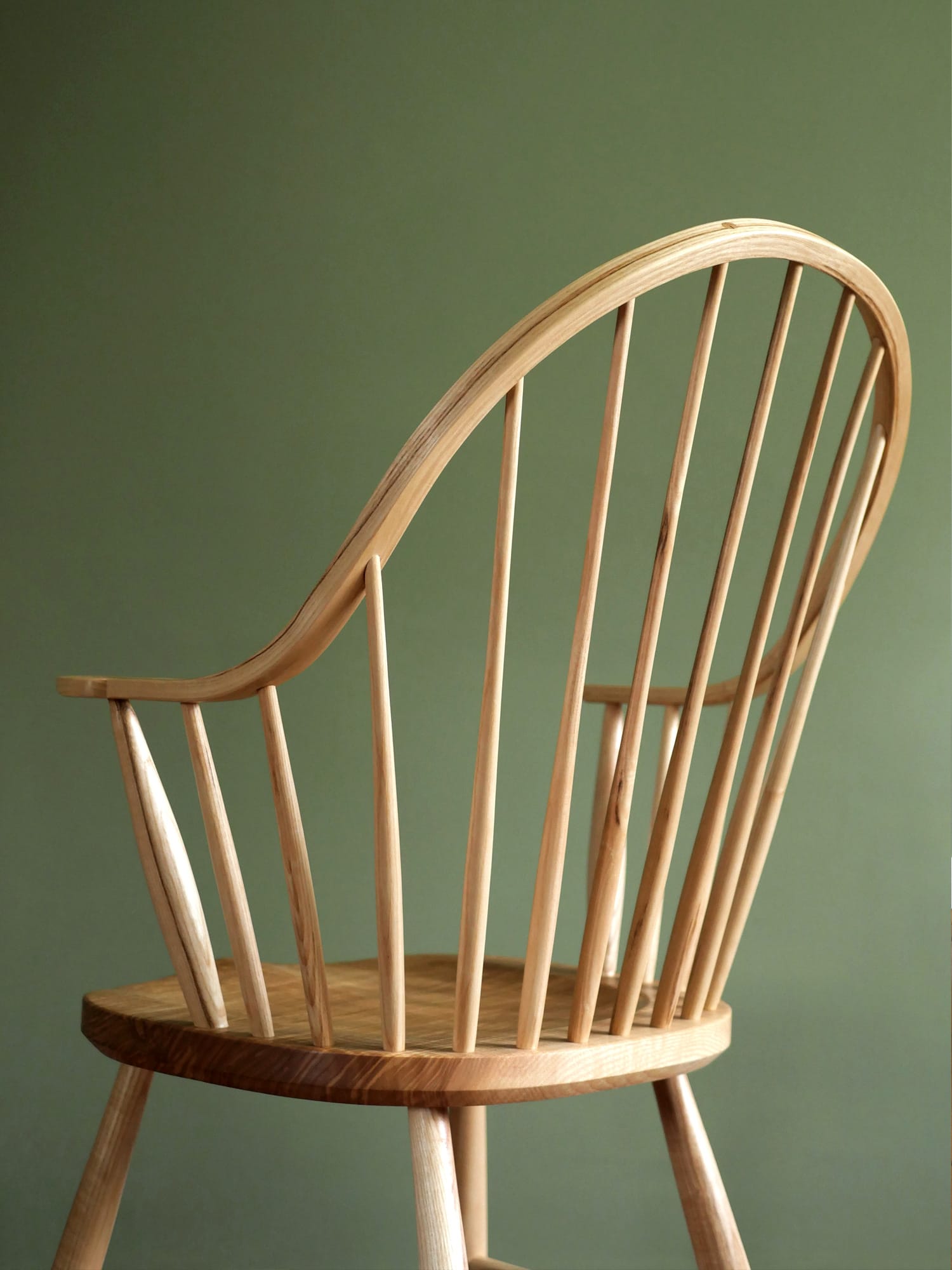 Handmade American style continuous arm Windsor chair in ash.