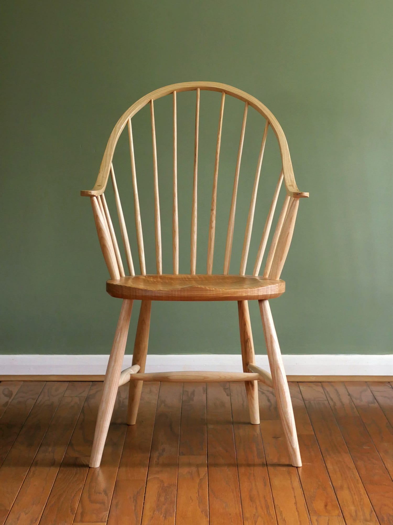 Handmade American style continuous arm Windsor chair in ash.