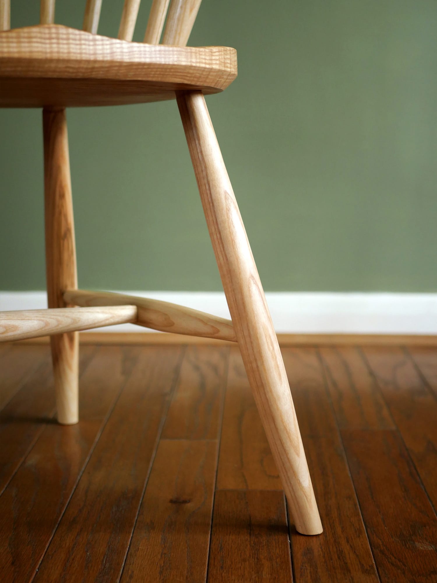 Handmade American style continuous arm Windsor chair in ash.