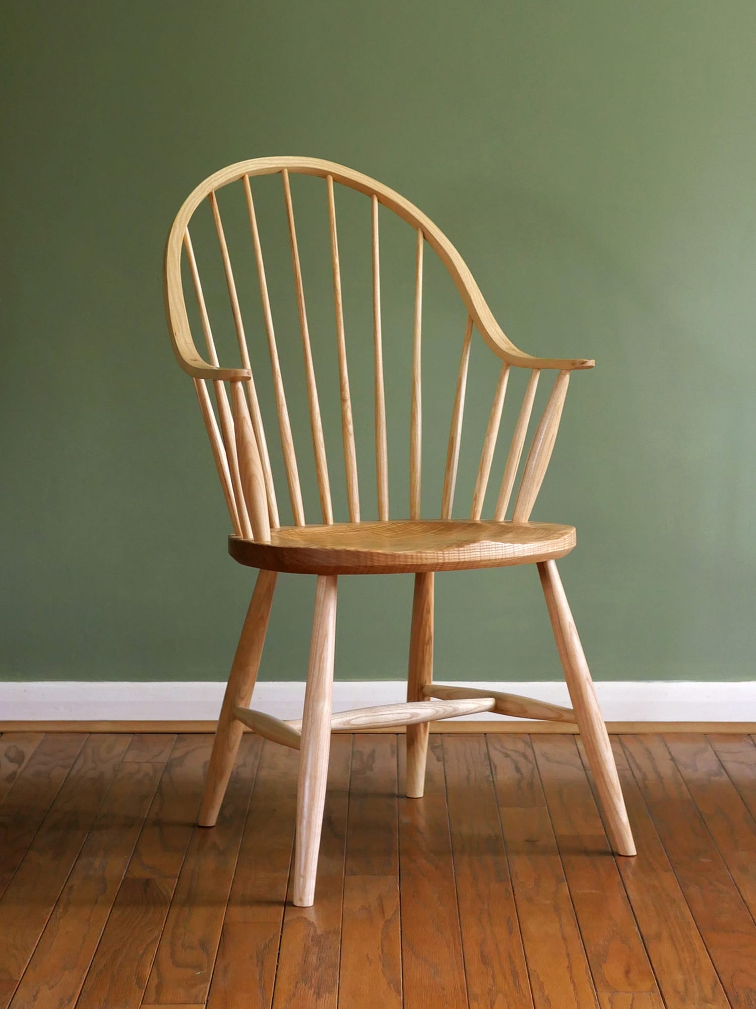 Handmade American style continuous arm Windsor chair in ash.